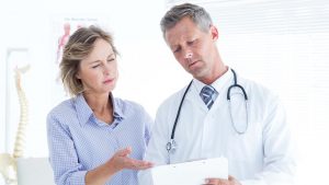 Doctor showing his notes to his patient